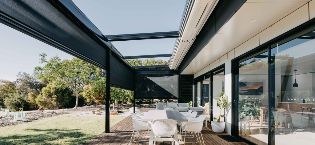 Retractable roof and outdoor blinds enclosing alfresco dining area with timber decking